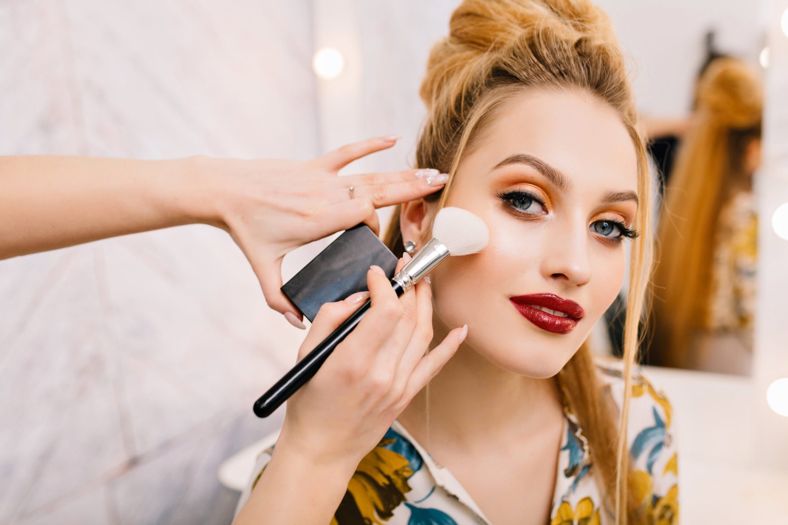 Preparing to party, carnival, celebration of attractive young women in beauty salon. Making makeup, stylish coiffure, professional stylist, cheerful mood, fashionable model
